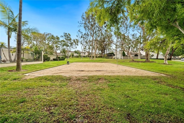 view of community featuring volleyball court, a yard, and fence