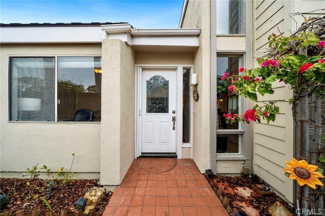 view of exterior entry with stucco siding