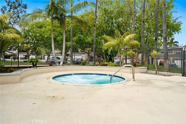 view of pool with a community hot tub and fence