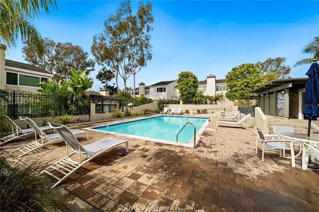 community pool featuring a patio and fence