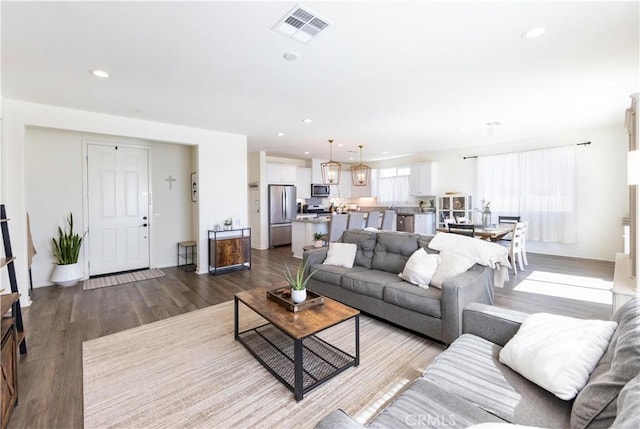 living room with visible vents, recessed lighting, and dark wood-type flooring