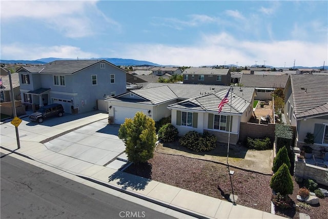 view of front facade with fence, driveway, stucco siding, a tiled roof, and a residential view