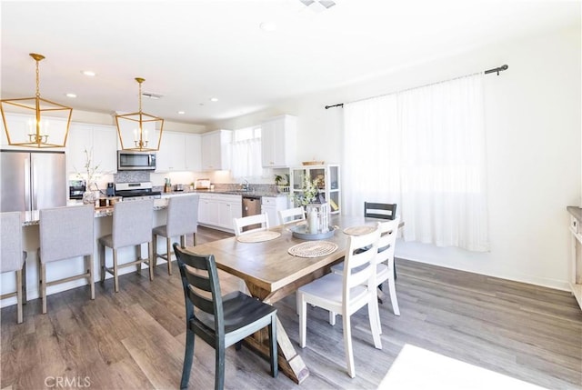 dining space featuring a notable chandelier, recessed lighting, and wood finished floors