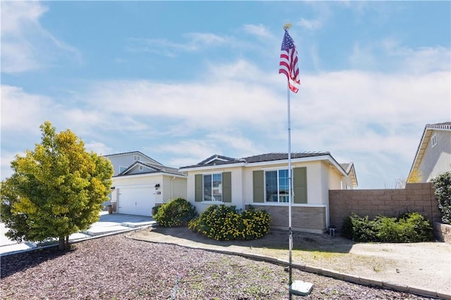 ranch-style home featuring an attached garage, fence, driveway, and stucco siding