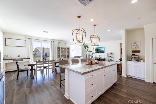 kitchen with visible vents, dark wood-style floors, a center island, recessed lighting, and white cabinets