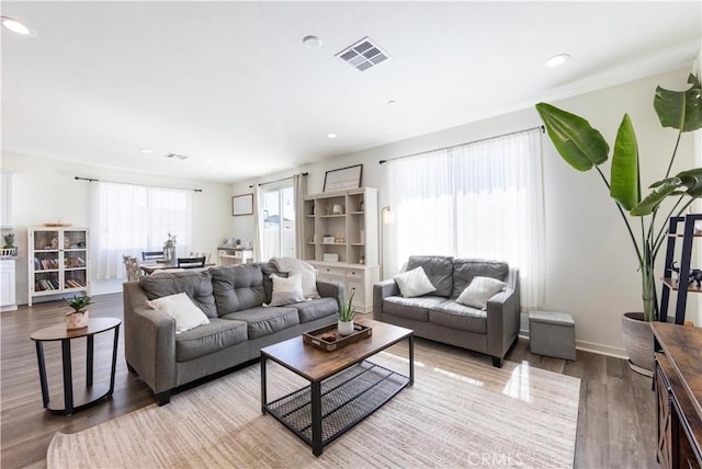 living area featuring recessed lighting, wood finished floors, visible vents, and baseboards