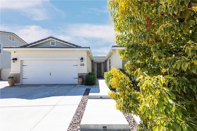 ranch-style home featuring stucco siding, an attached garage, and driveway