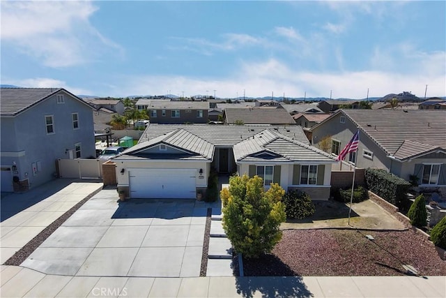 view of front of property with an attached garage, fence, a residential view, a tiled roof, and driveway