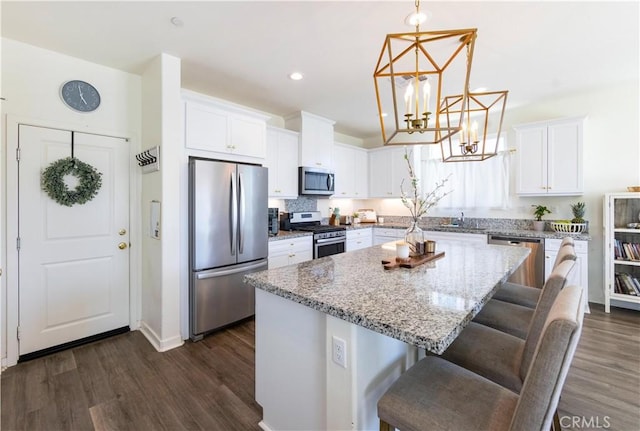 kitchen featuring white cabinetry, dark wood-style floors, appliances with stainless steel finishes, and a kitchen island