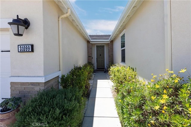 doorway to property featuring stucco siding