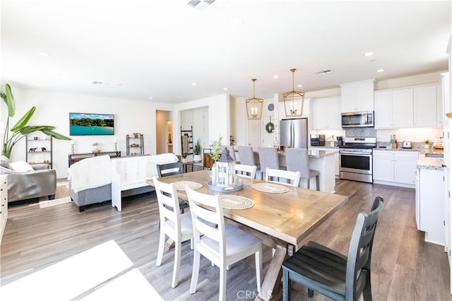 dining area with light wood-style flooring and recessed lighting