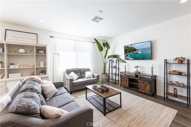 living area featuring visible vents, recessed lighting, baseboards, and wood finished floors