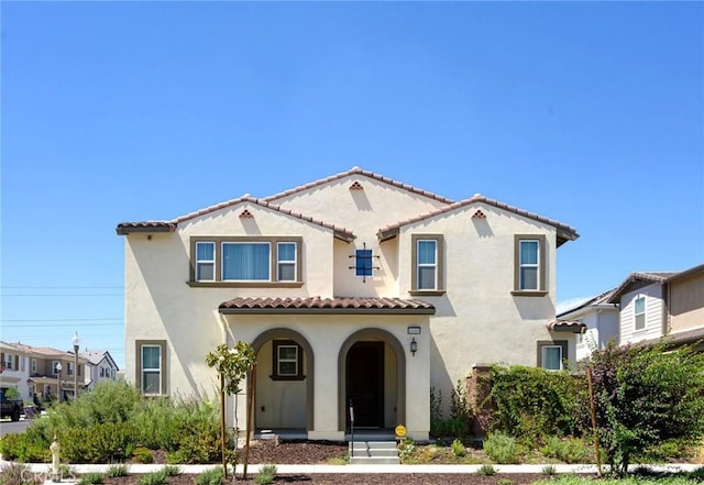 mediterranean / spanish-style home featuring stucco siding and a tile roof