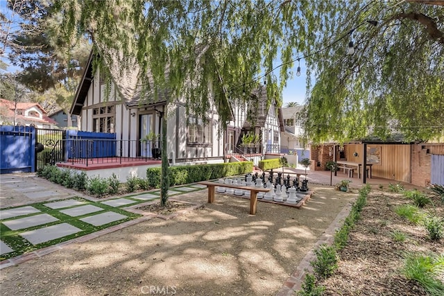 view of community with a wooden deck, a patio, and fence