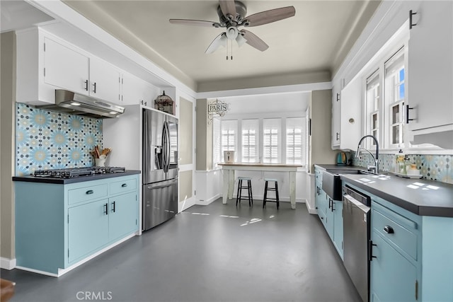 kitchen featuring blue cabinets, appliances with stainless steel finishes, under cabinet range hood, and a sink