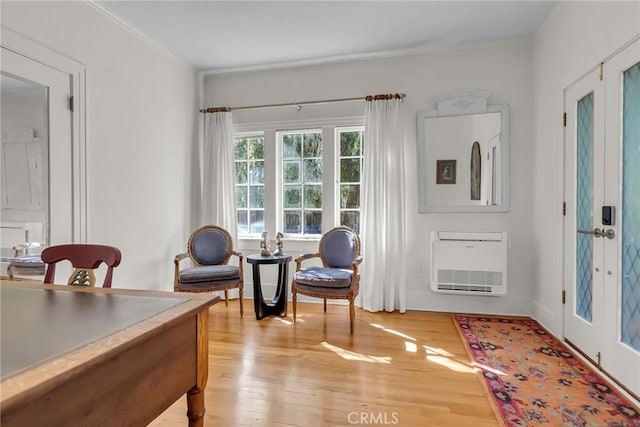 interior space with heating unit, light wood finished floors, and french doors