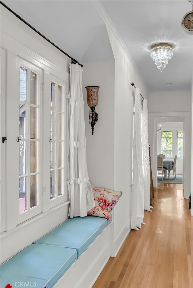 mudroom with a notable chandelier, baseboards, light wood-type flooring, and ornamental molding