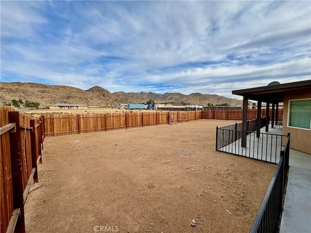 view of yard featuring a mountain view and a fenced backyard