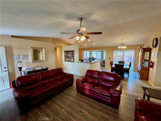 living area with lofted ceiling, wood finished floors, baseboards, and a textured ceiling