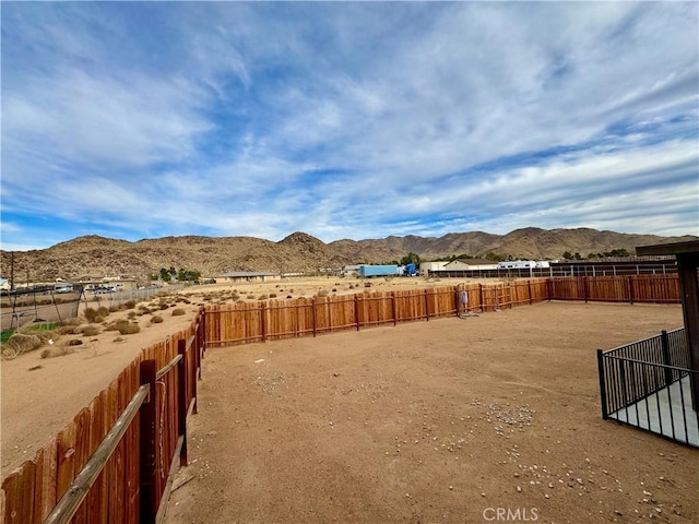 view of yard featuring a mountain view and fence