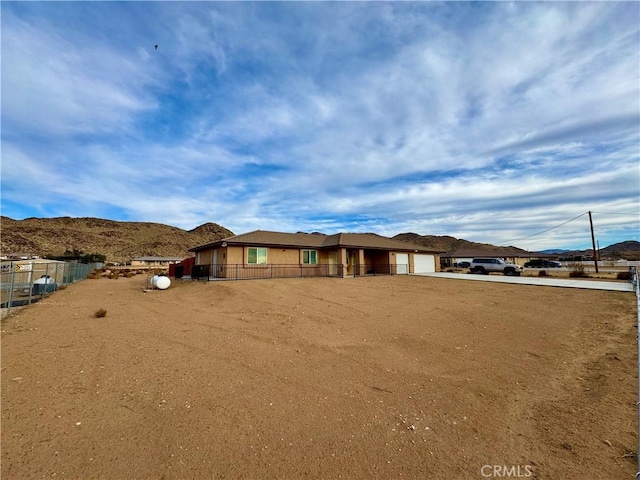 view of front of house with a mountain view and fence