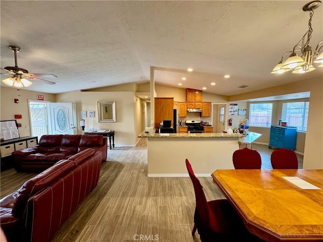 dining area with lofted ceiling, recessed lighting, light wood-style floors, a textured ceiling, and ceiling fan with notable chandelier