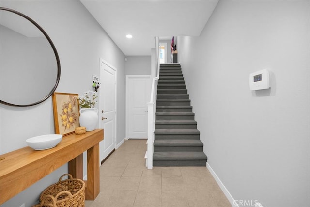 staircase with recessed lighting, baseboards, and tile patterned flooring