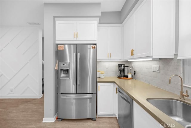 kitchen featuring a sink, light countertops, white cabinets, and stainless steel appliances