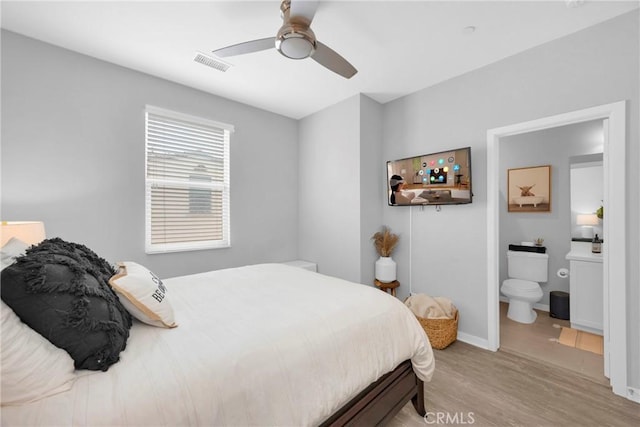 bedroom with visible vents, baseboards, ceiling fan, light wood-type flooring, and ensuite bathroom