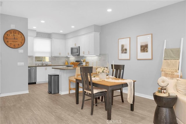 dining space featuring recessed lighting, light wood-type flooring, and baseboards