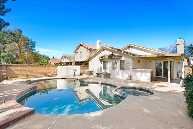 view of swimming pool featuring a patio, cooling unit, a fenced backyard, and a pool with connected hot tub