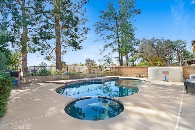 view of swimming pool featuring a patio area, a pool with connected hot tub, and fence private yard