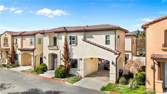 mediterranean / spanish-style home with stucco siding, concrete driveway, and a tile roof