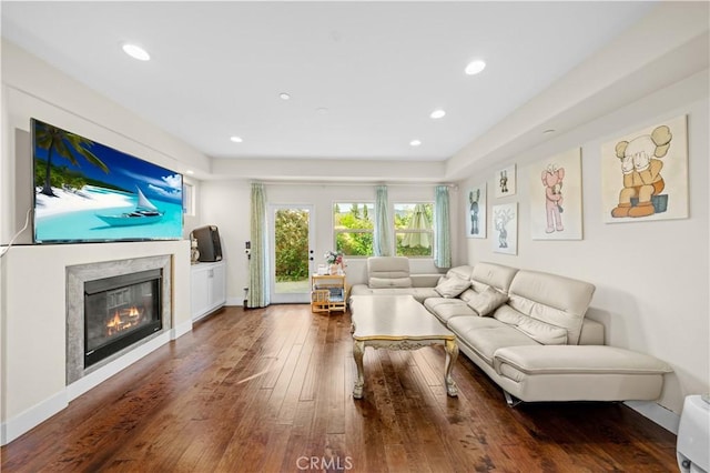 living area featuring a premium fireplace, recessed lighting, baseboards, and hardwood / wood-style flooring