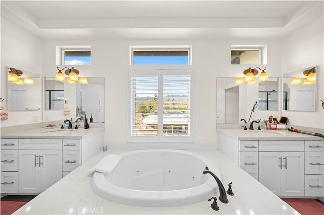 bathroom featuring plenty of natural light, a whirlpool tub, and a sink