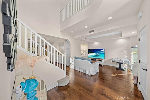 interior space featuring stairway, visible vents, baseboards, recessed lighting, and hardwood / wood-style flooring