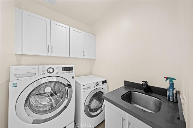 laundry room featuring washer and dryer, cabinet space, and a sink