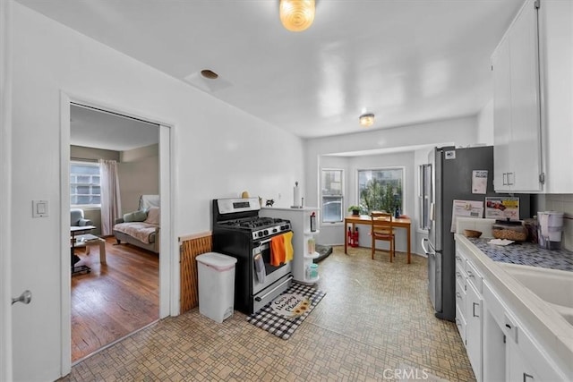 kitchen featuring white cabinetry, light countertops, appliances with stainless steel finishes, and a sink