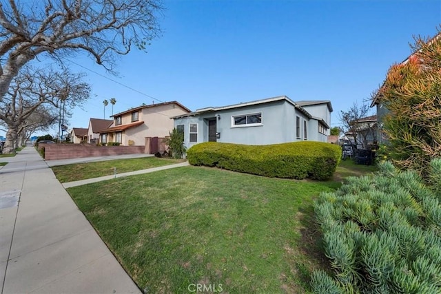 view of front of home with stucco siding and a front lawn