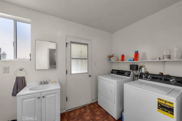 washroom featuring washing machine and clothes dryer, a healthy amount of sunlight, cabinet space, and a sink