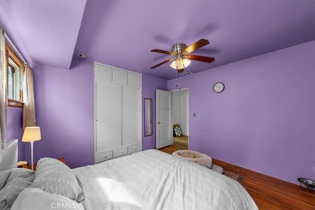 bedroom featuring a closet, visible vents, ceiling fan, and wood finished floors