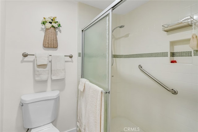 bathroom with a stall shower and toilet