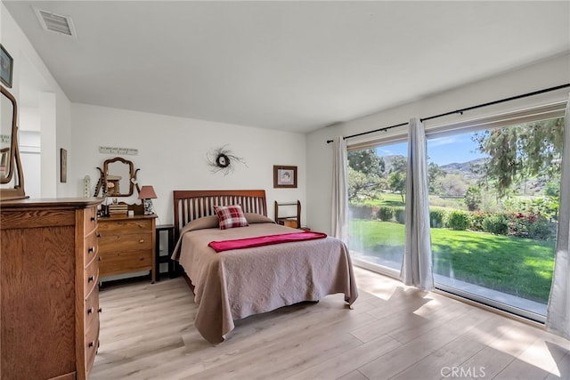 bedroom with access to exterior, visible vents, and light wood finished floors