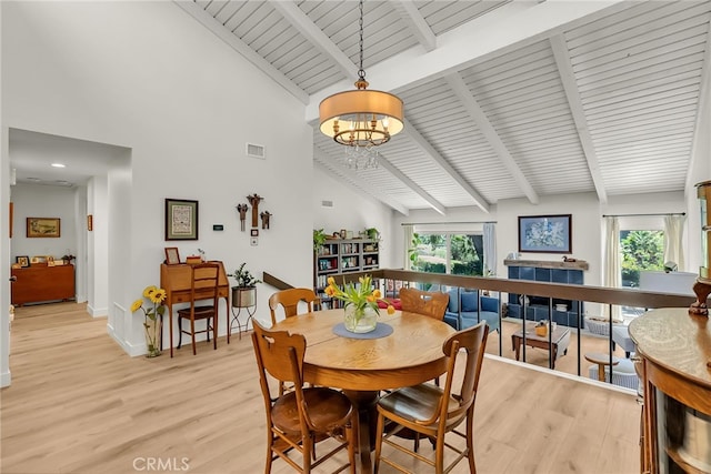 dining area with a chandelier, beam ceiling, light wood-type flooring, and a wealth of natural light