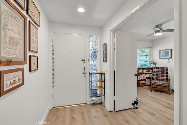 entryway with baseboards, light wood-style flooring, and a ceiling fan