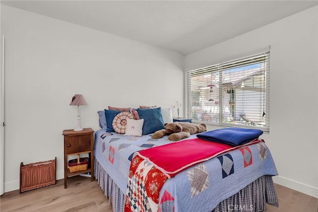 bedroom with baseboards and wood finished floors