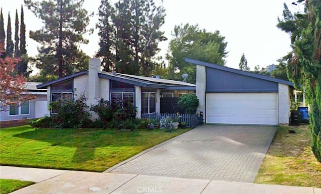 mid-century home featuring a front yard and decorative driveway