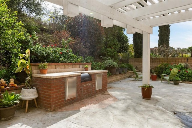 view of patio featuring area for grilling, a pergola, and fence