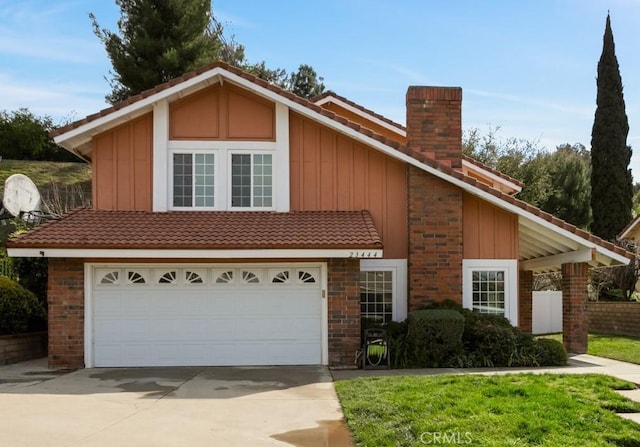 view of front of house with board and batten siding, concrete driveway, a garage, a chimney, and a tiled roof