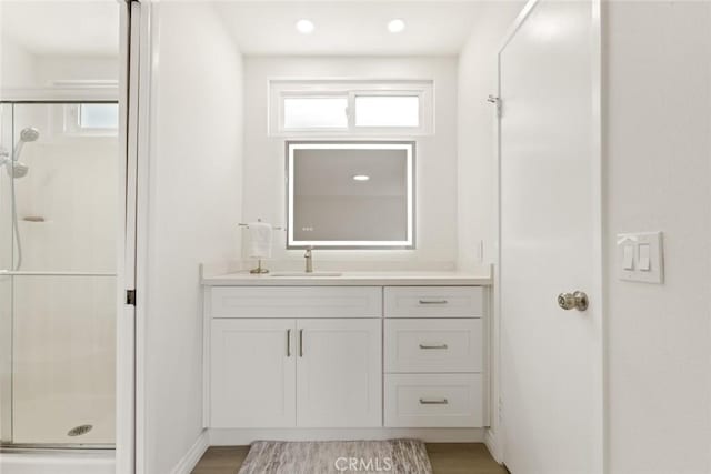 full bath with vanity, wood finished floors, and a shower stall